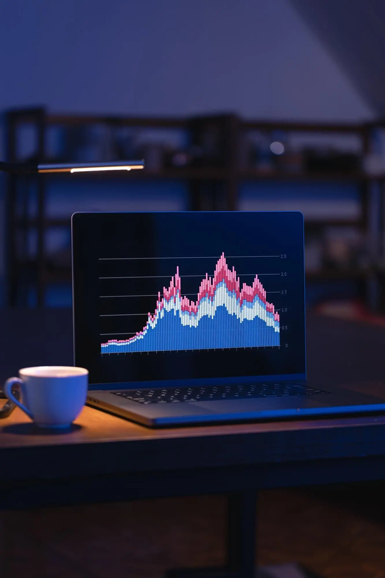 Компьютер в темной комнате, на экране — графики.